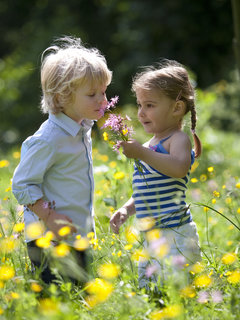 two children smelling flowes