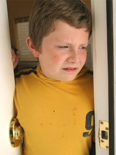unhappy boy in doorway